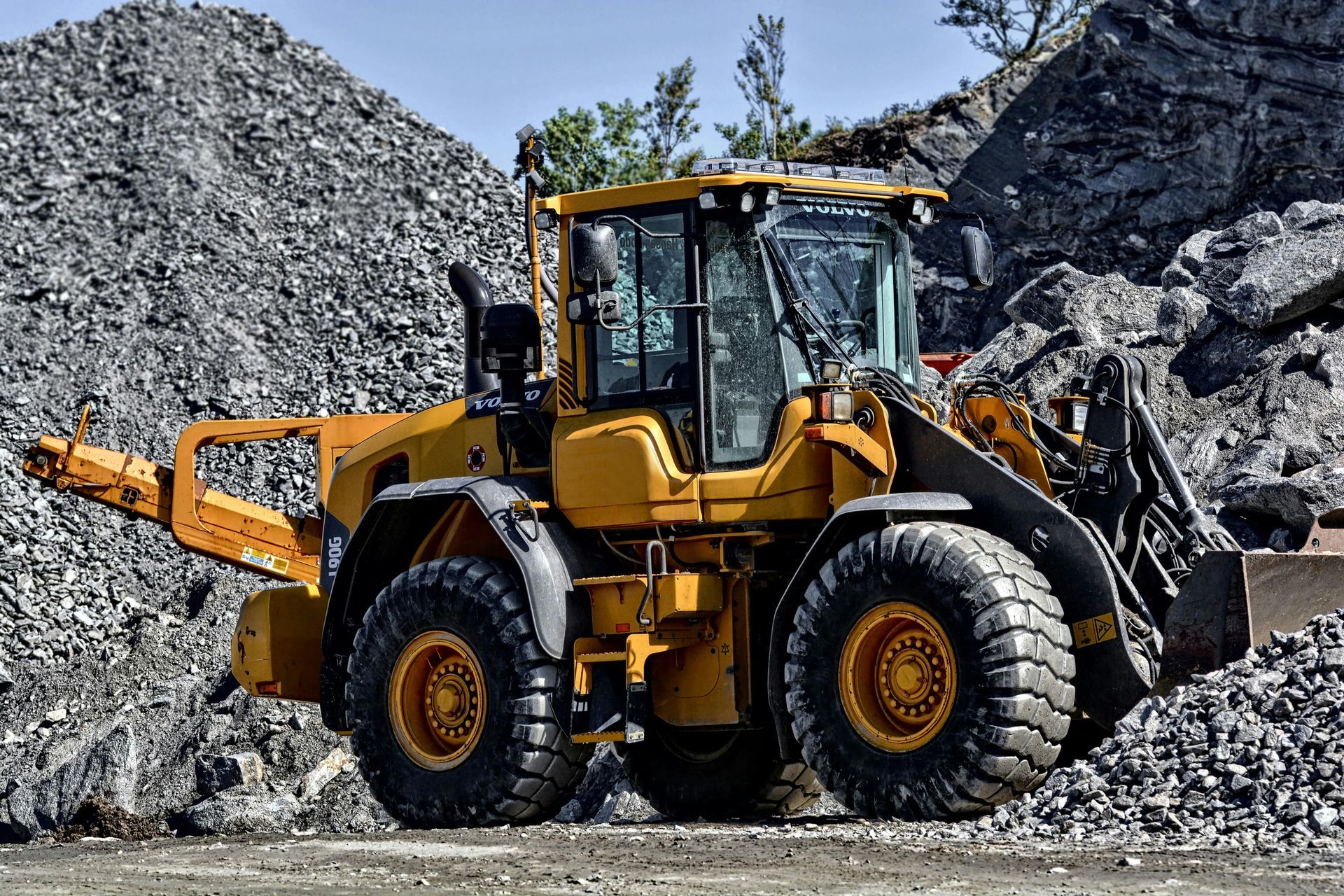 A yellow bulldozer is parked in front of a pile of rocks.