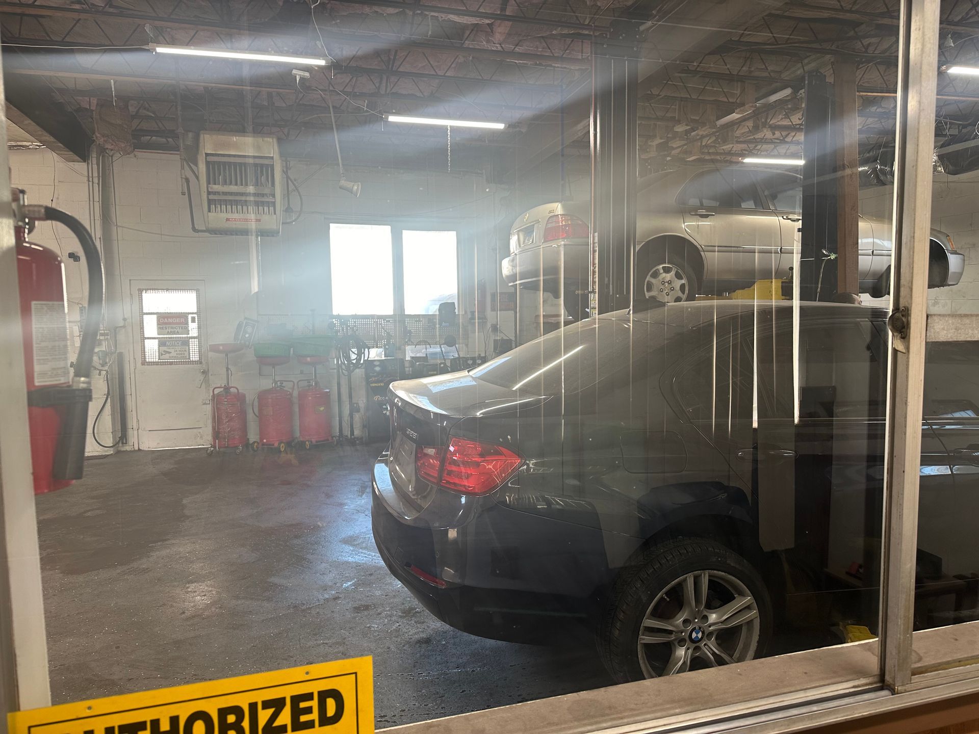 A car is sitting on a lift in a garage. | Strike Force Mobile Mechanic llc
