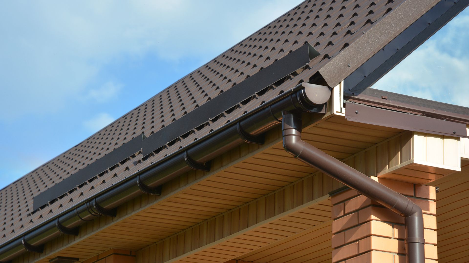 A close up of a gutter on the roof of a house.
