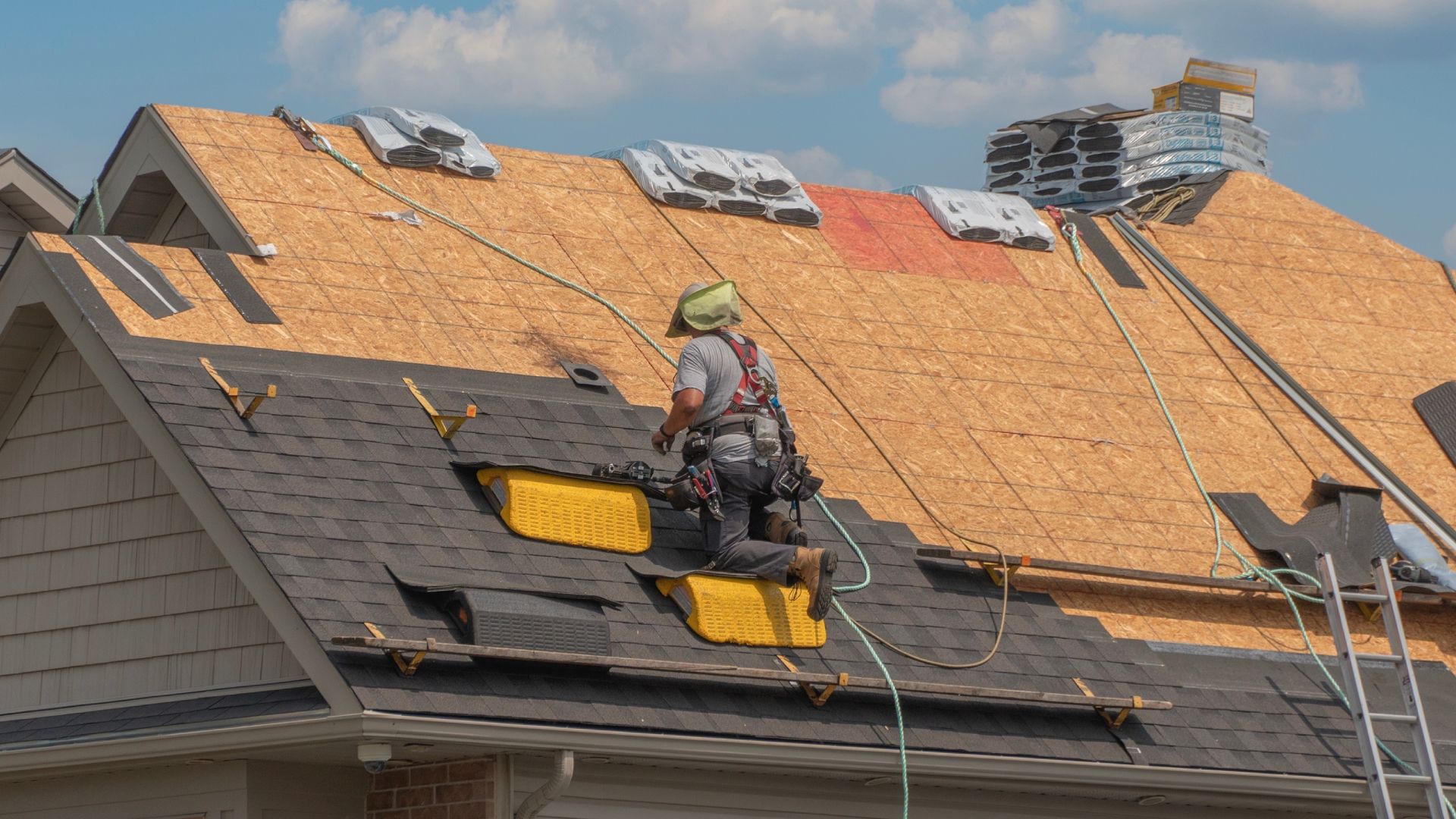 A man is working on the roof of a house.