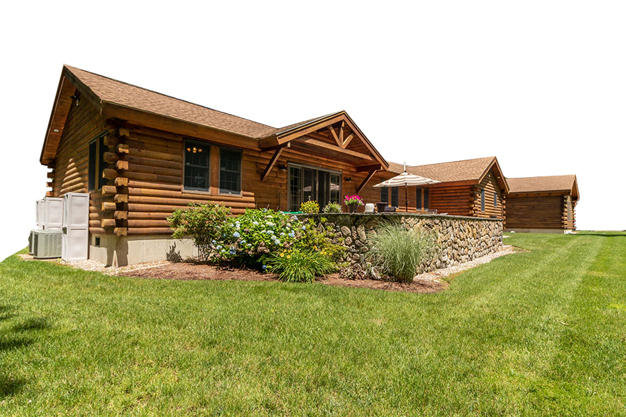 A log cabin is sitting on top of a lush green field.