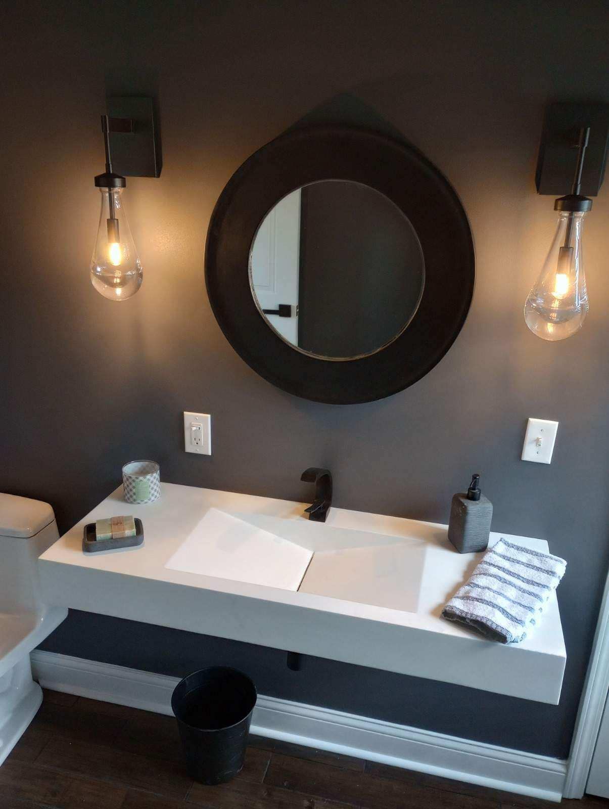 A bathroom with a sink , mirror , and toilet.