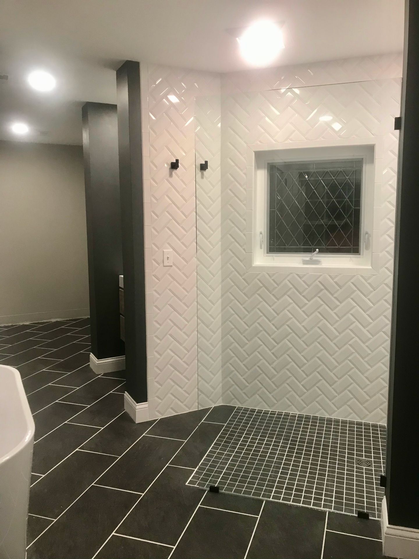 A bathroom with black and white tiles and a window