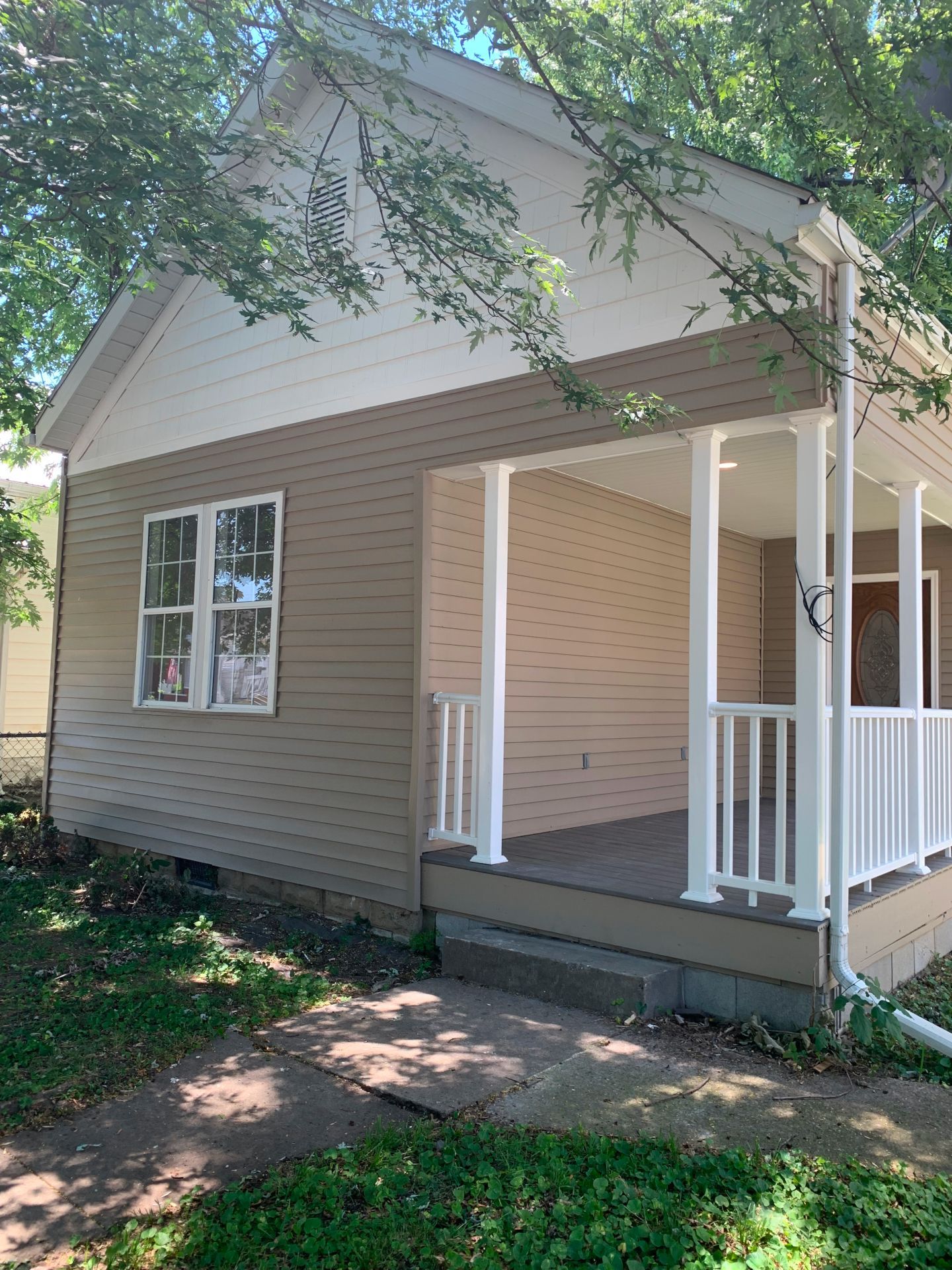 A small house with a porch and a white railing.