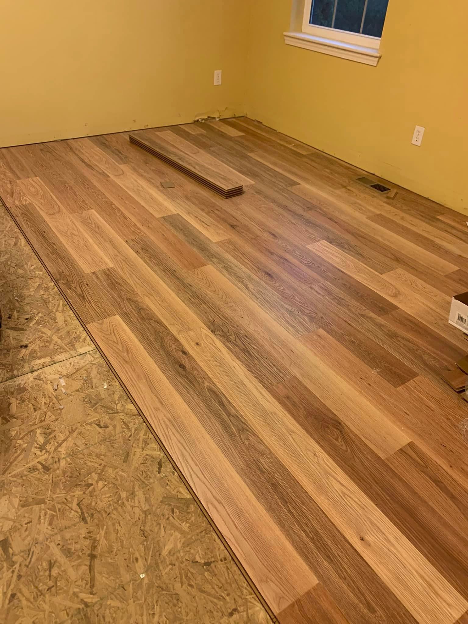A room with a wooden floor and a window.