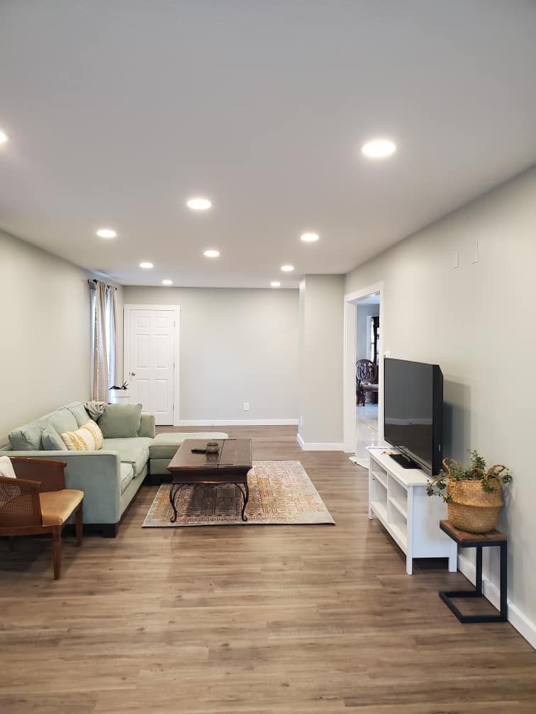 A living room with a couch , coffee table , and television.