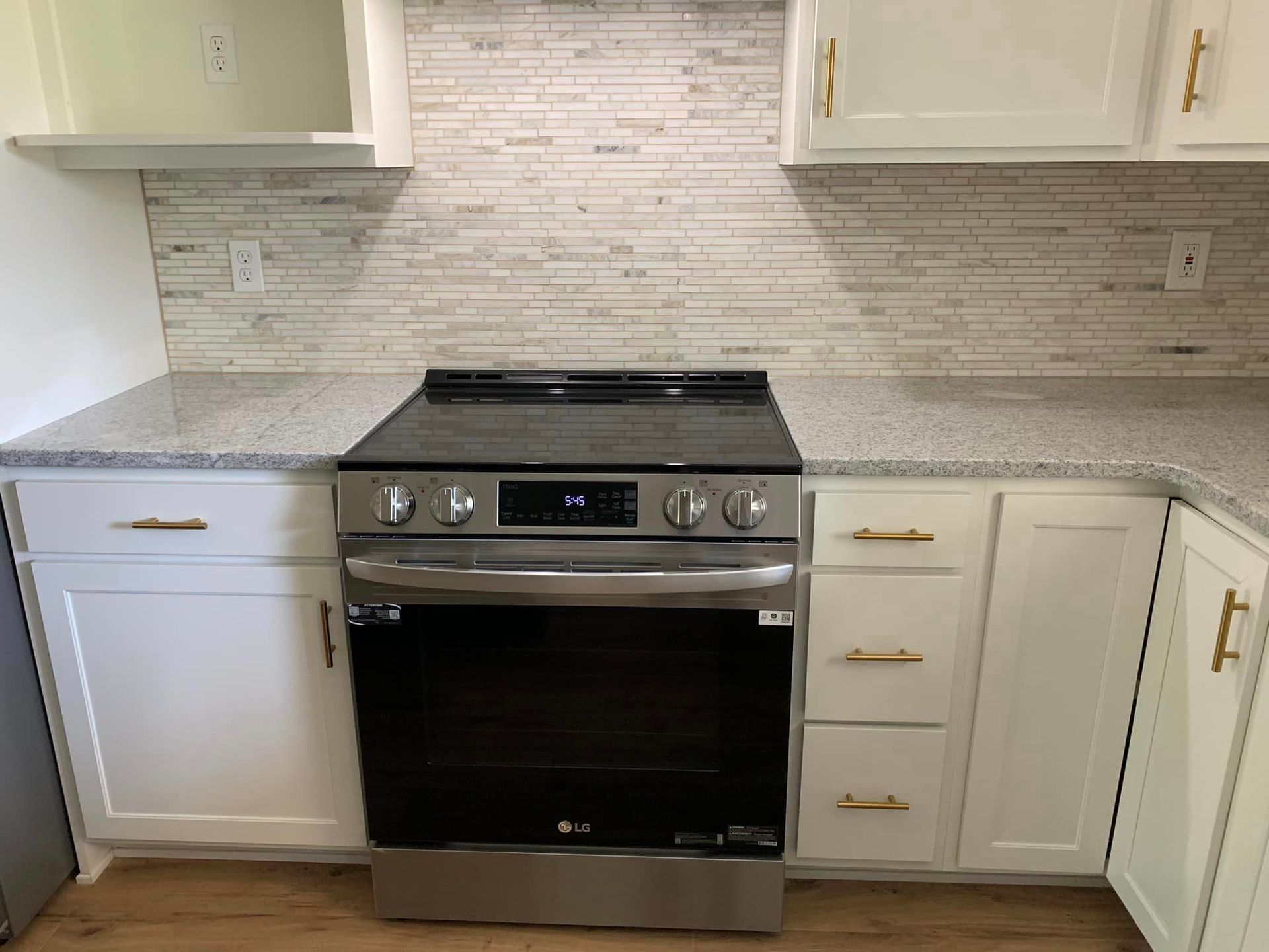 A stainless steel stove and oven in a kitchen with white cabinets.