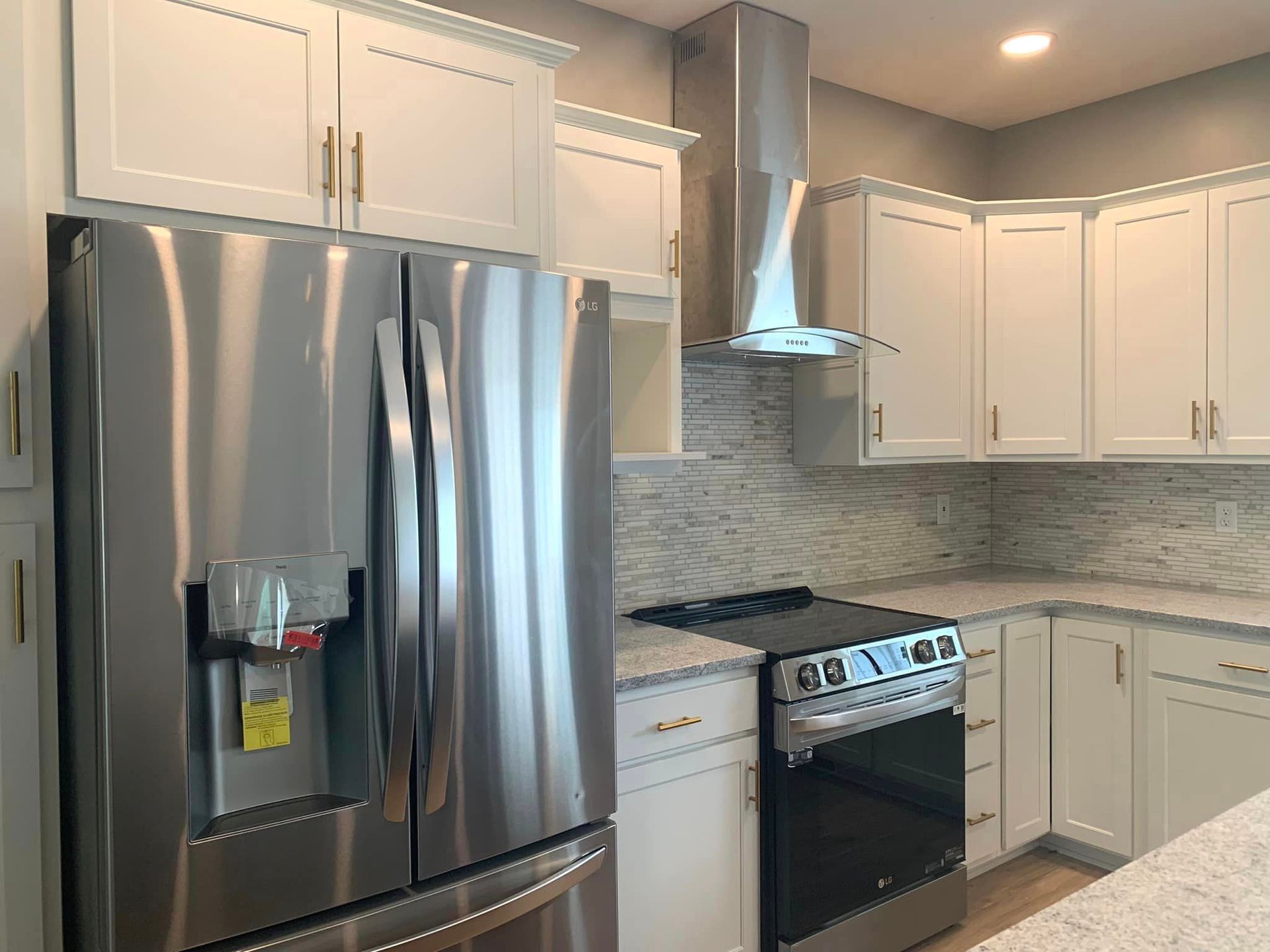 A kitchen with stainless steel appliances and white cabinets.
