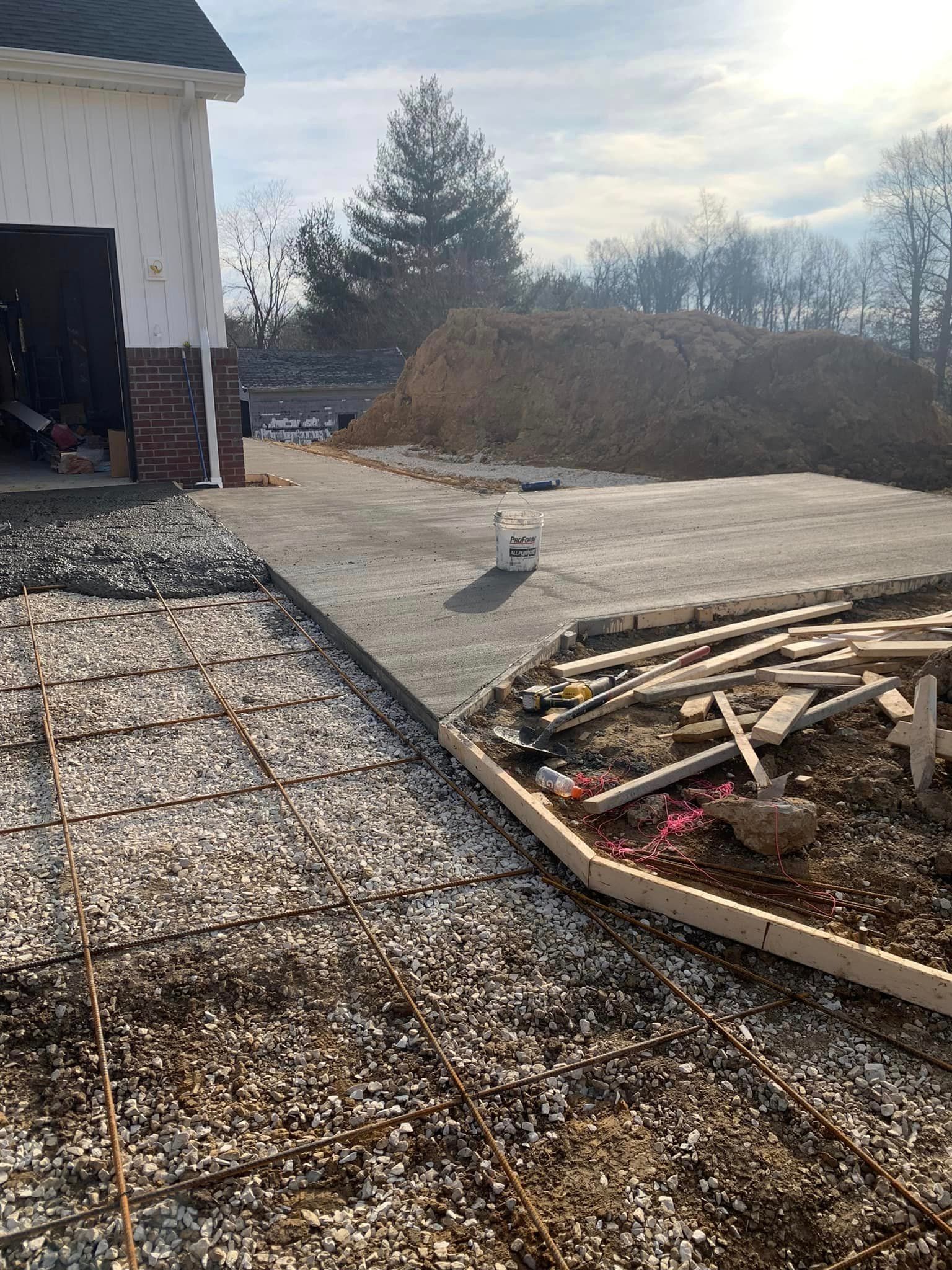 A concrete driveway is being built in front of a garage.