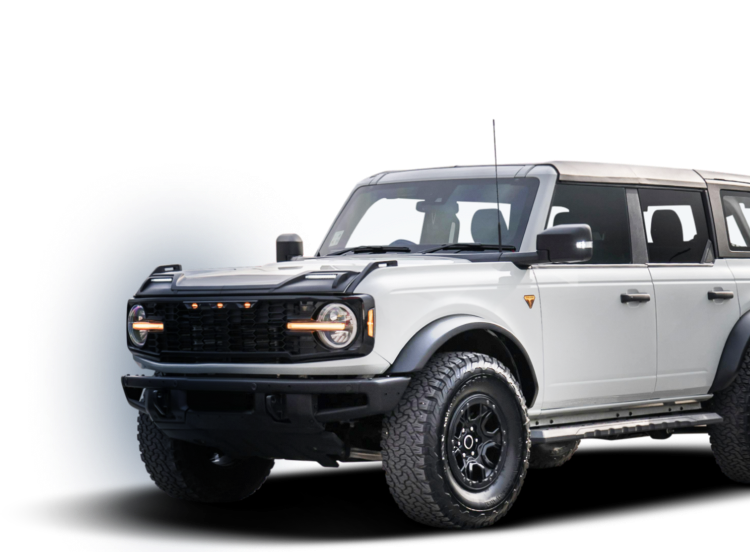White Ford Bronco SUV with black accents and off-road tires, parked, isolated on white.