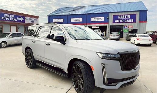 Gray SUV parked in front of Destin Auto Care with other cars and buildings in the background.