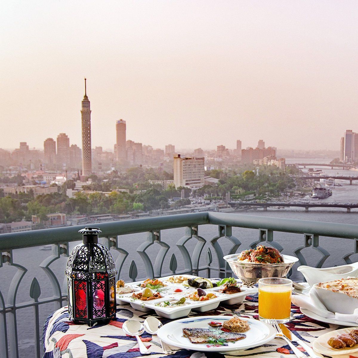 A table with plates of food and a glass of orange juice