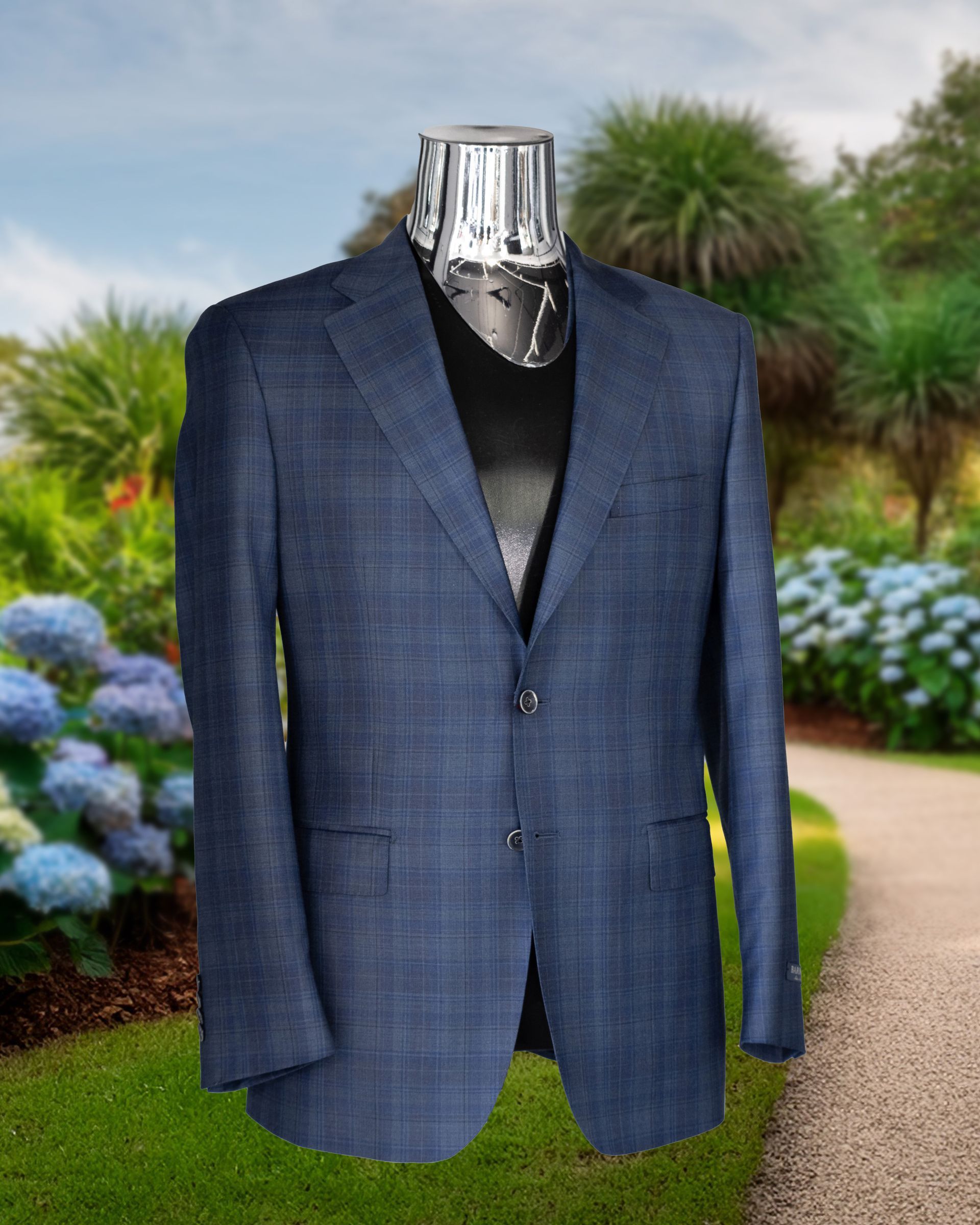 Blue plaid sport coat on a mannequin, outdoors with a garden path and flowers in the background.