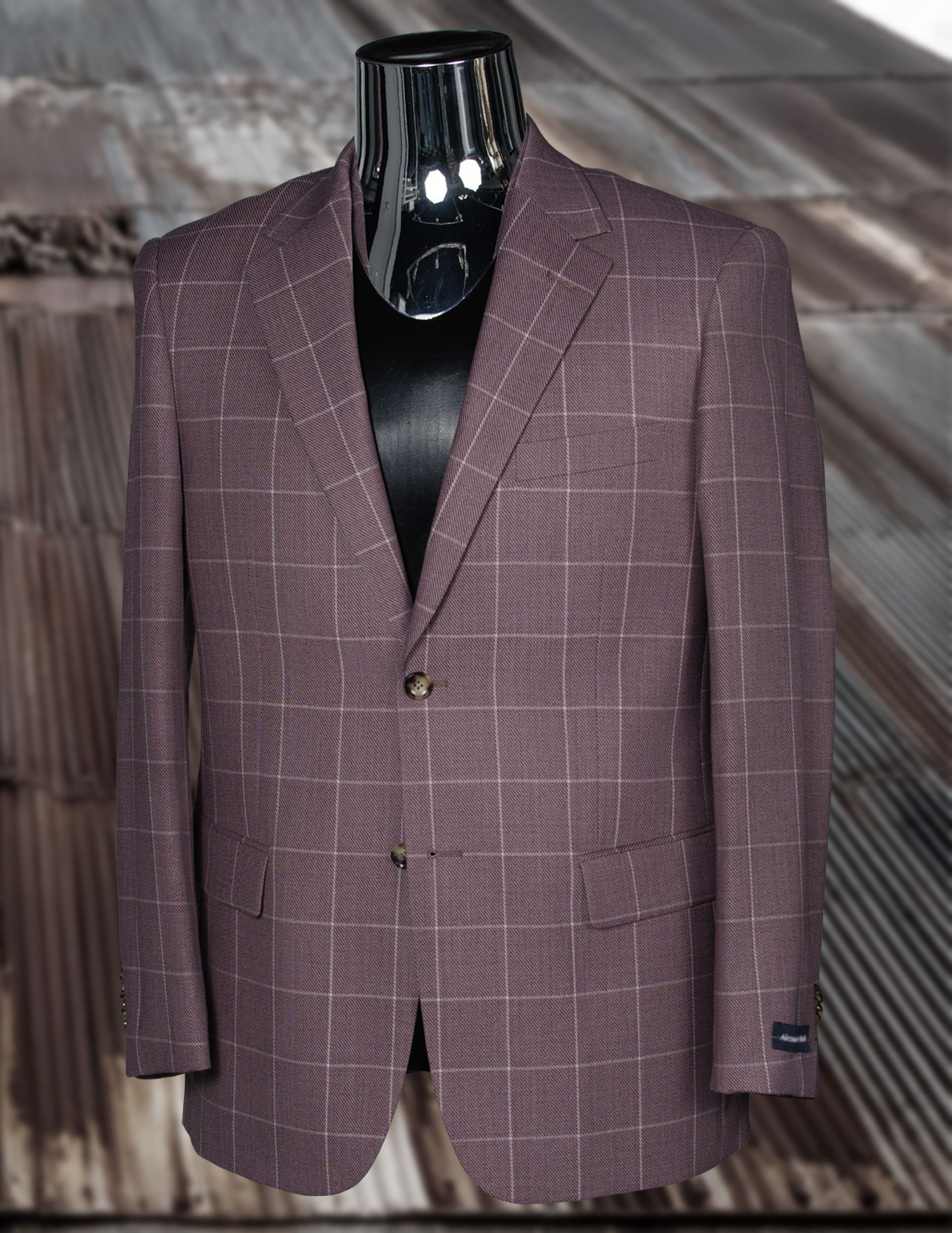 Mauve plaid men's blazer on a mannequin with two buttons, set against a metal sheet background.