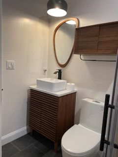 A bathroom with a sink , toilet and mirror.