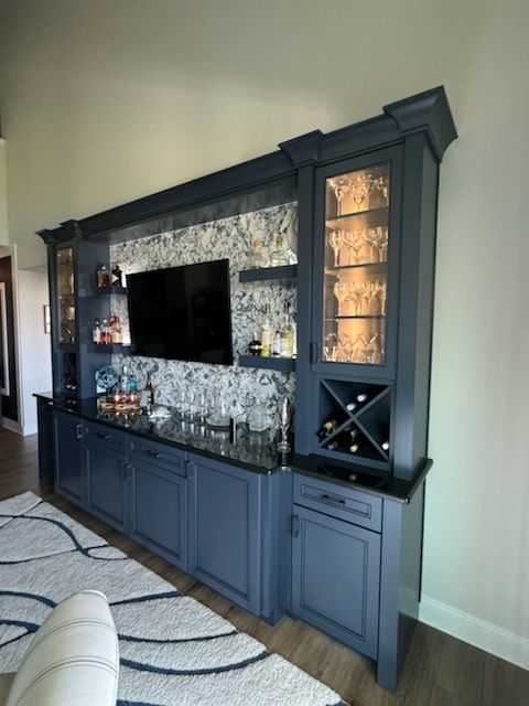 A living room with blue cabinets and a flat screen tv