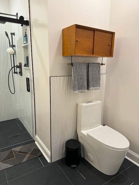 A bathroom with a toilet and a shower.
