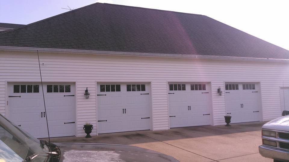 White garage with four doors and a dark roof.