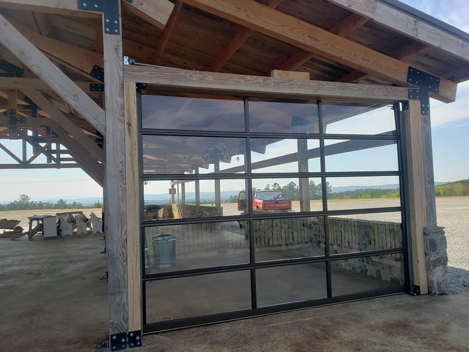 Open glass garage door in a wooden structure with a scenic outdoor view.