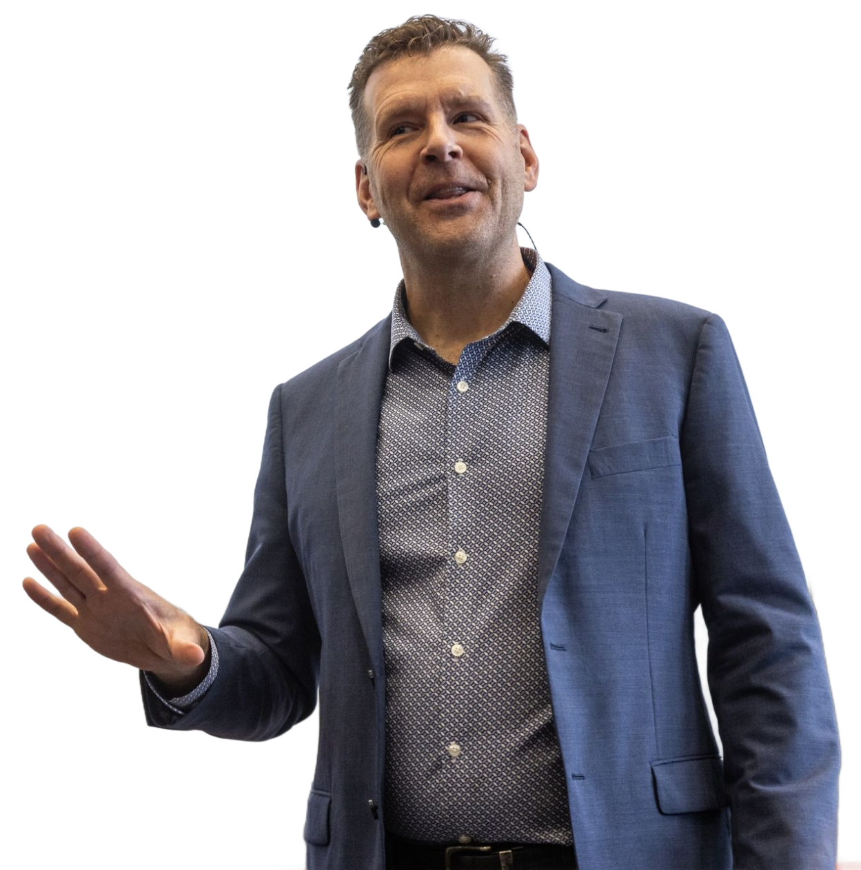 Pete Behrens in blue blazer gestures while presenting in front of a screen.