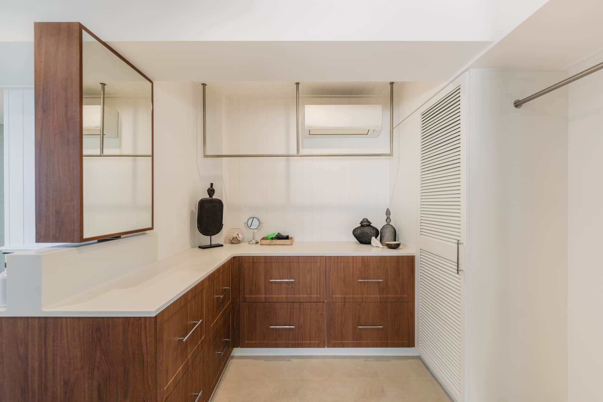 A bathroom with wooden cabinets , a sink , and a mirror — Kitchens by CCJS in Bungalow, QLD