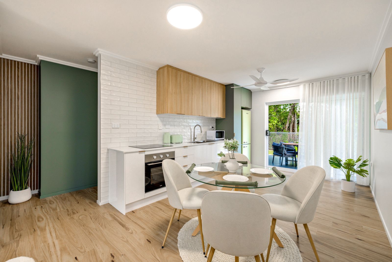 A living room with a dining table and chairs and a kitchen — Kitchens by CCJS in Bungalow, QLD