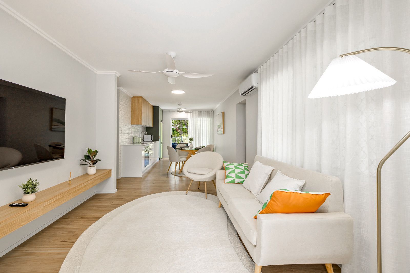 A living room with a couch and a flat screen tv — Kitchens by CCJS in Bungalow, QLD
