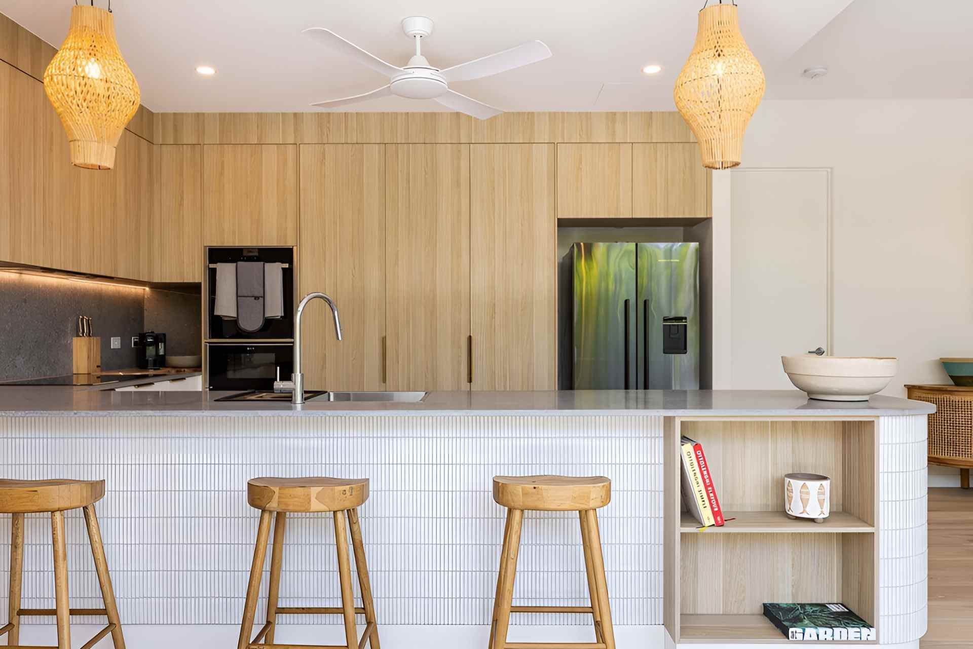 A Kitchen With Wooden Cabinets and Stools and a Ceiling Fan — Kitchens by CCJS in Bungalow, QLD