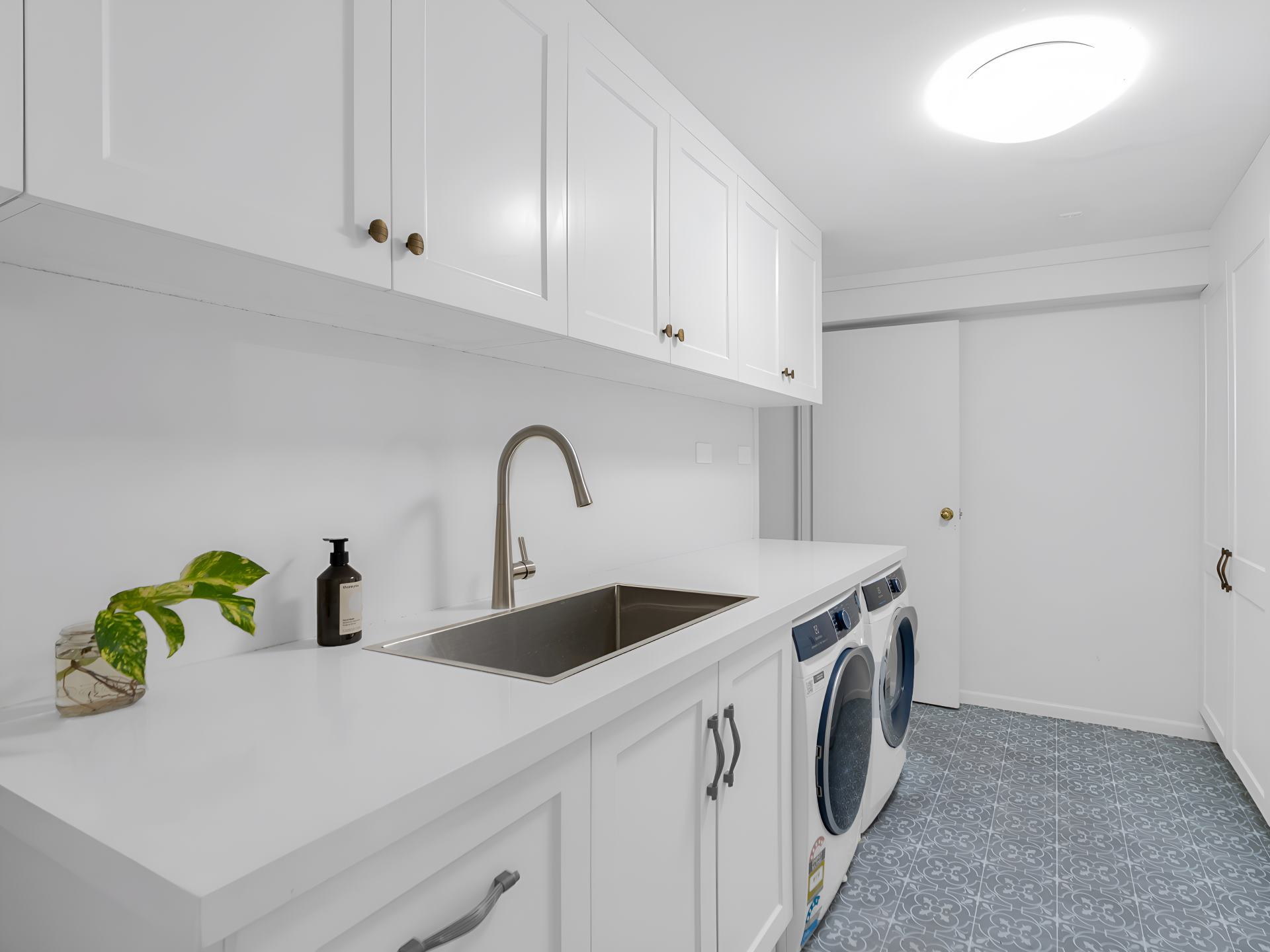 A Laundry Room With White Cabinets, a Sink, and a Washer and Dryer — Kitchens by CCJS in Bungalow, QLD