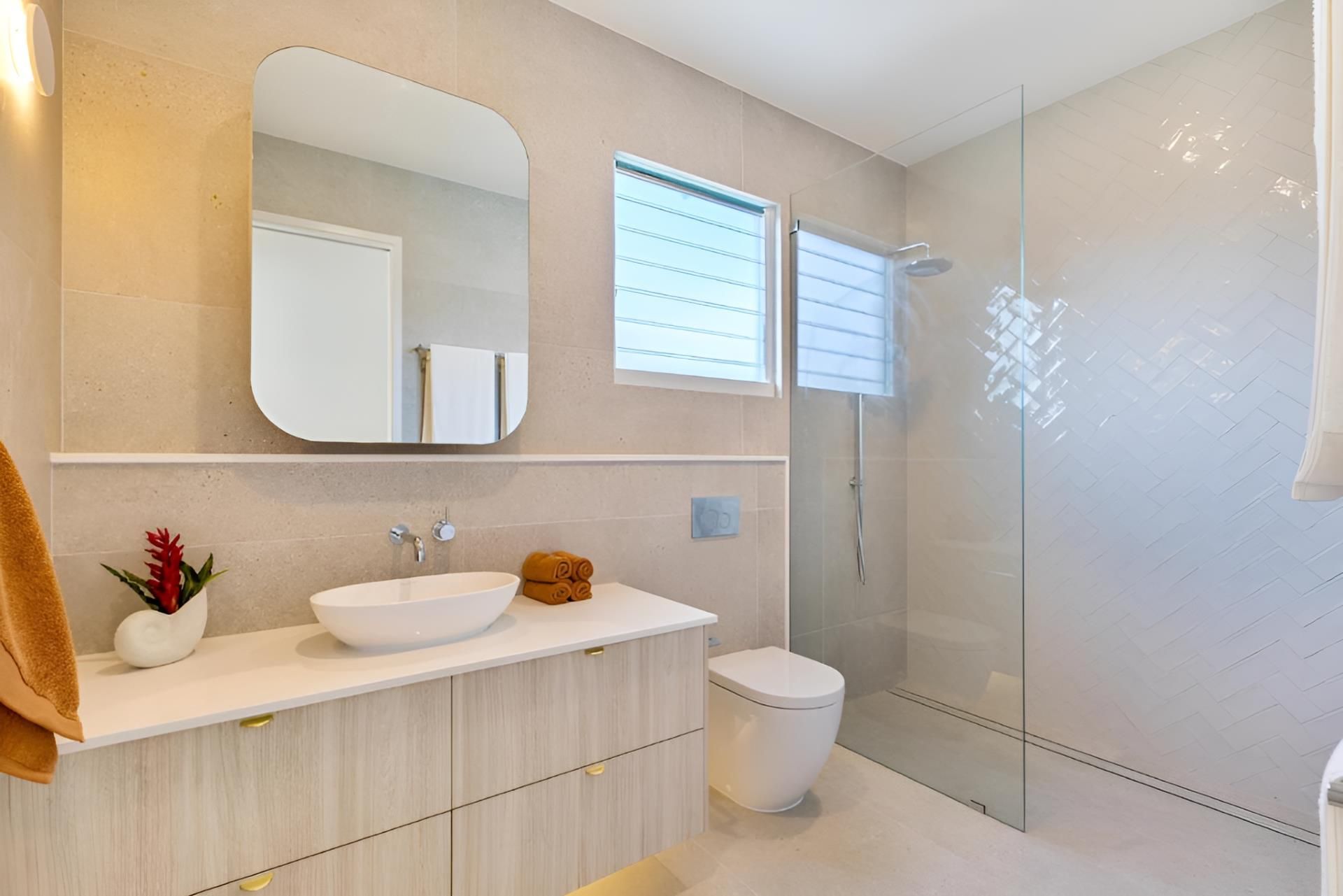 A Bathroom With a Sink, Toilet, Mirror and Walk in Shower — Kitchens by CCJS in Port Douglas, QLD