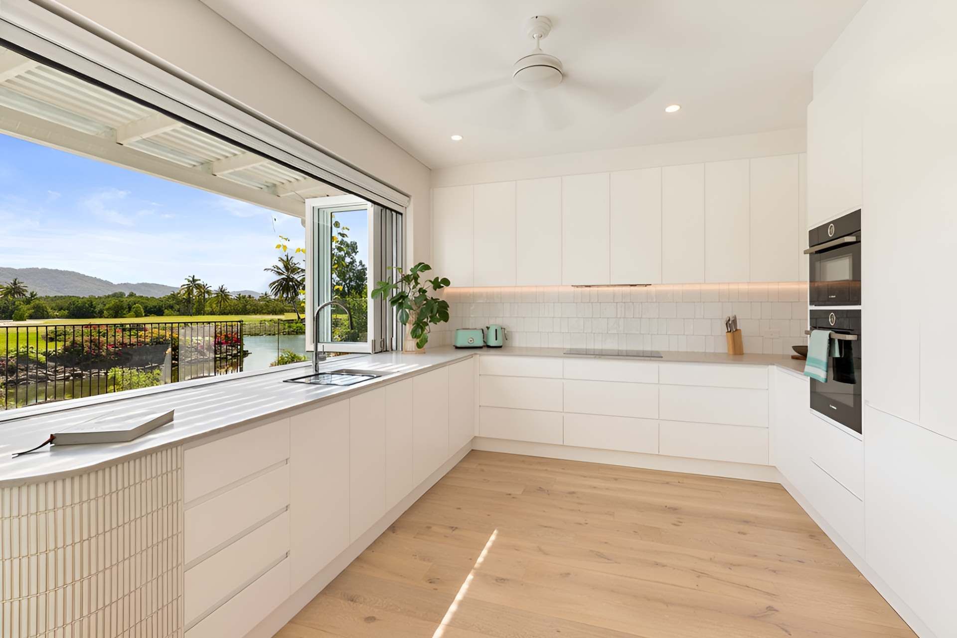 A Kitchen With White Cabinets and a Large Window — Kitchens by CCJS in Bungalow, QLD