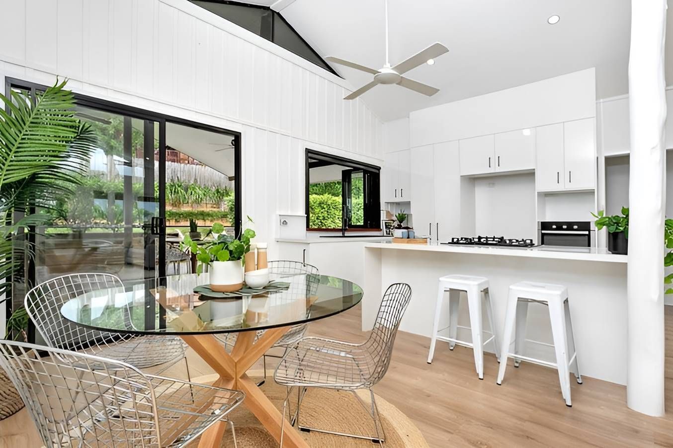 A Kitchen With a Glass Table and Chairs and a Ceiling Fan — Kitchens by CCJS in Bungalow, QLD