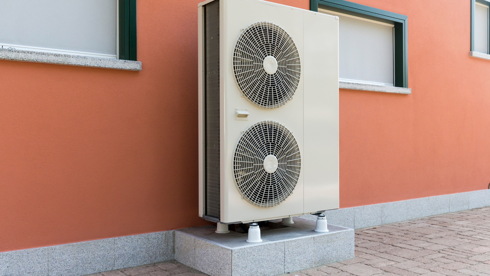 a large air conditioner is sitting on the side of a building .