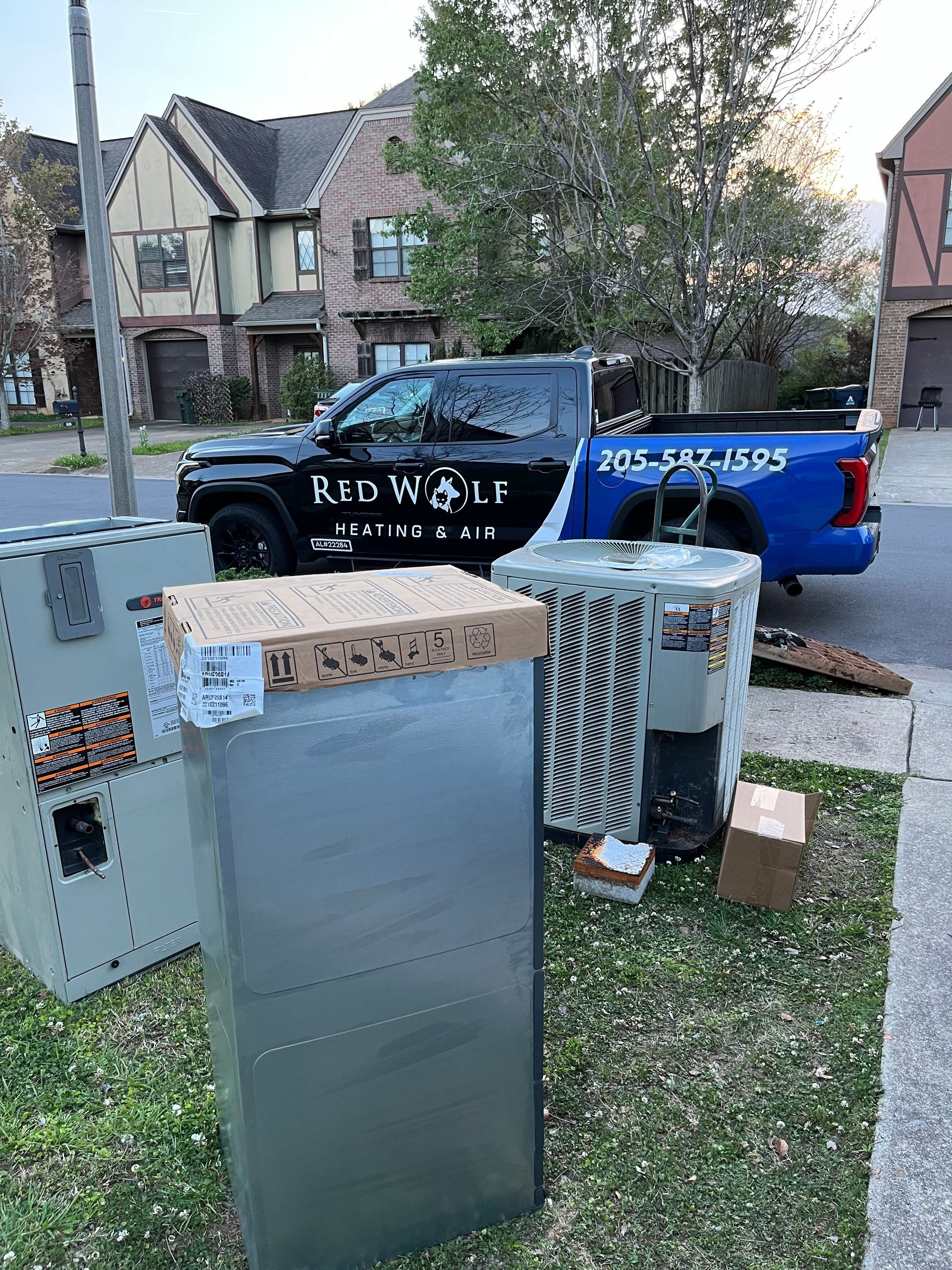 A blue truck is parked in front of a house.