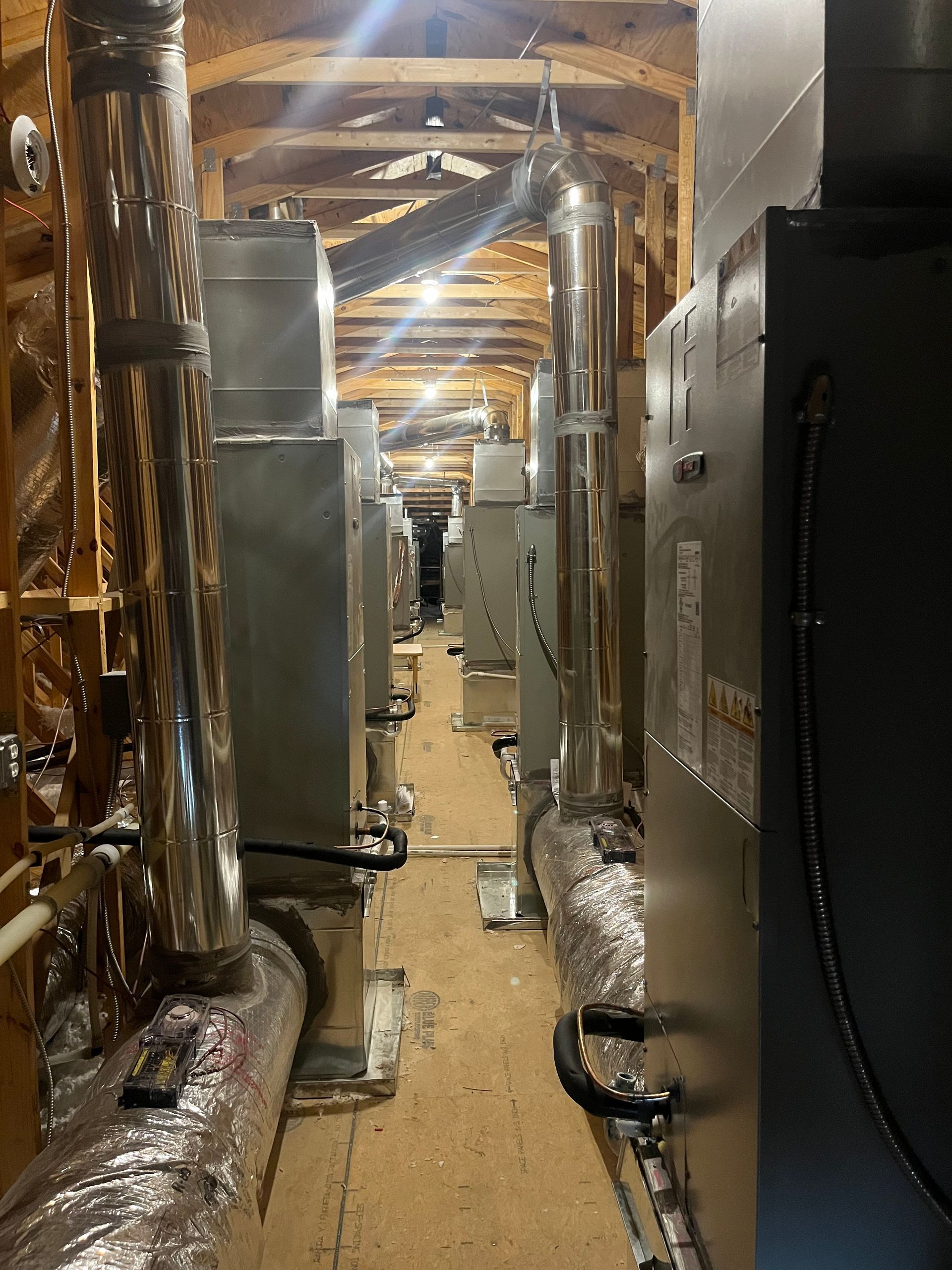 A very long hallway with a lot of pipes going through it.