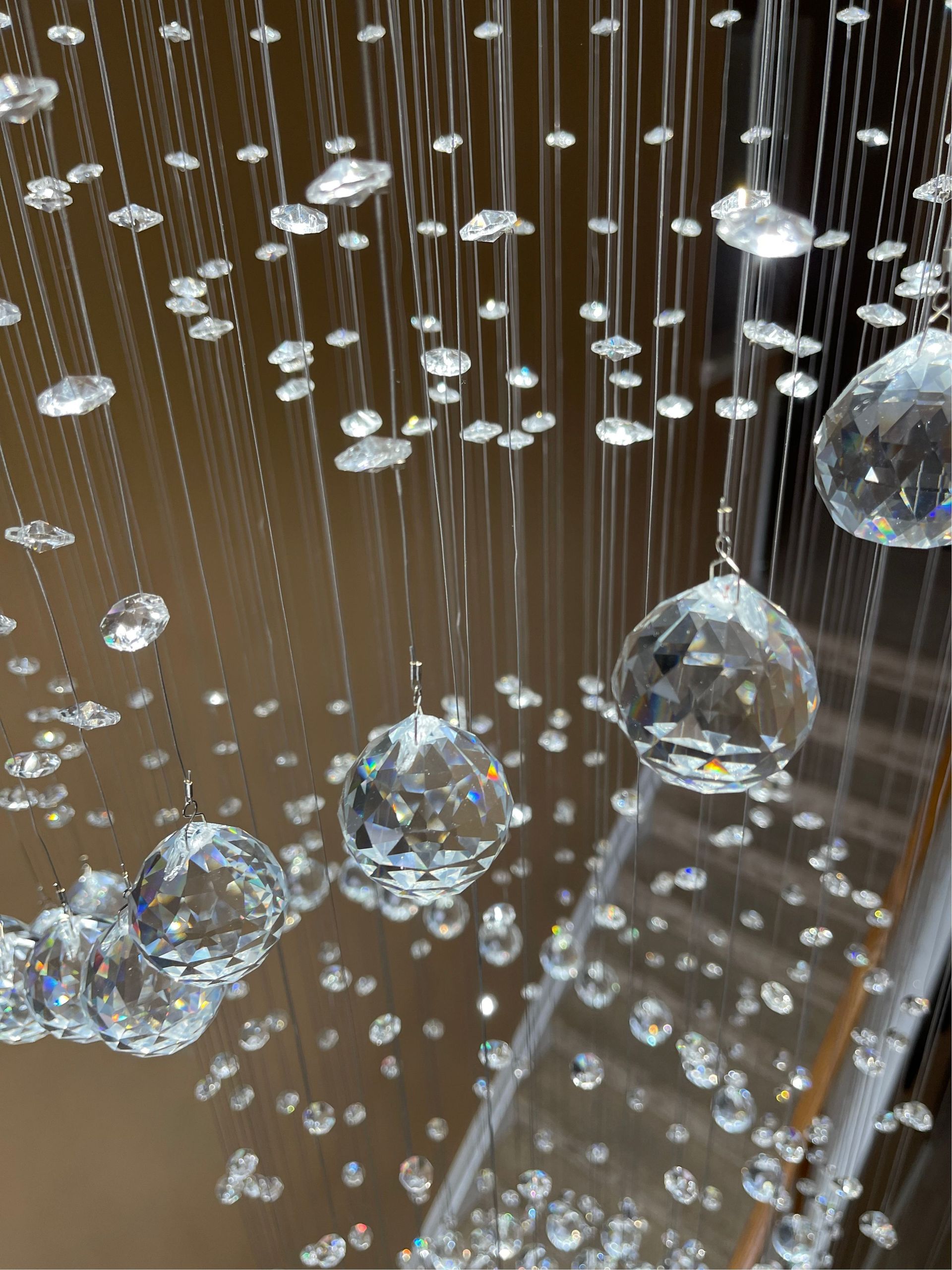 Hanging crystal chandelier with decorative lighting accents in a stairway installation