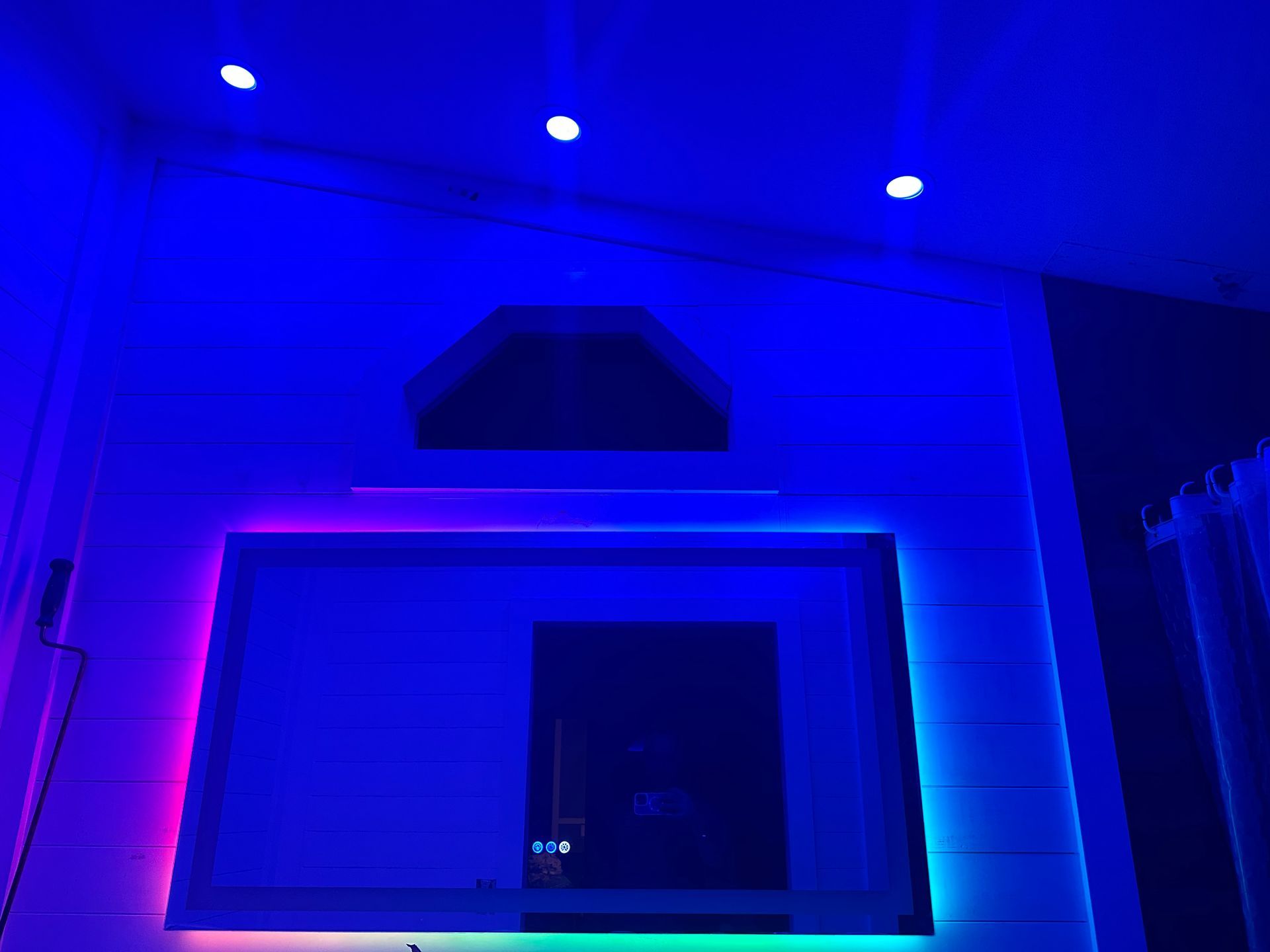 Custom RGB LED lighting setup installed on decorative accent wall with recessed lights