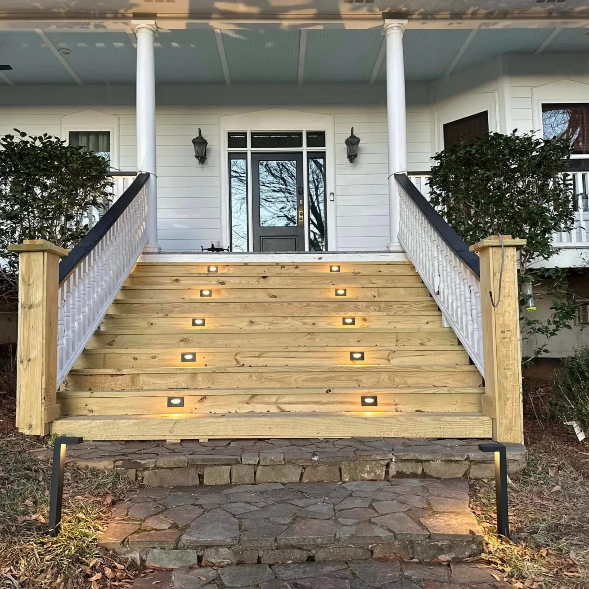 Outdoor step lighting installed on front porch stairs for safety and curb appeal