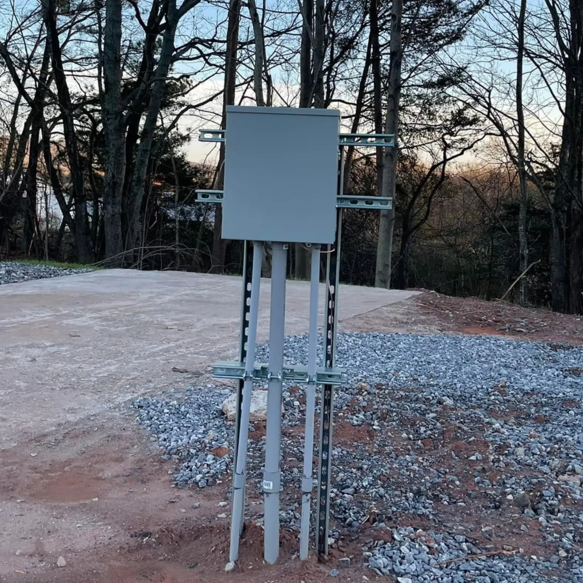 Ground-mounted electrical service panel base prepared for new construction power