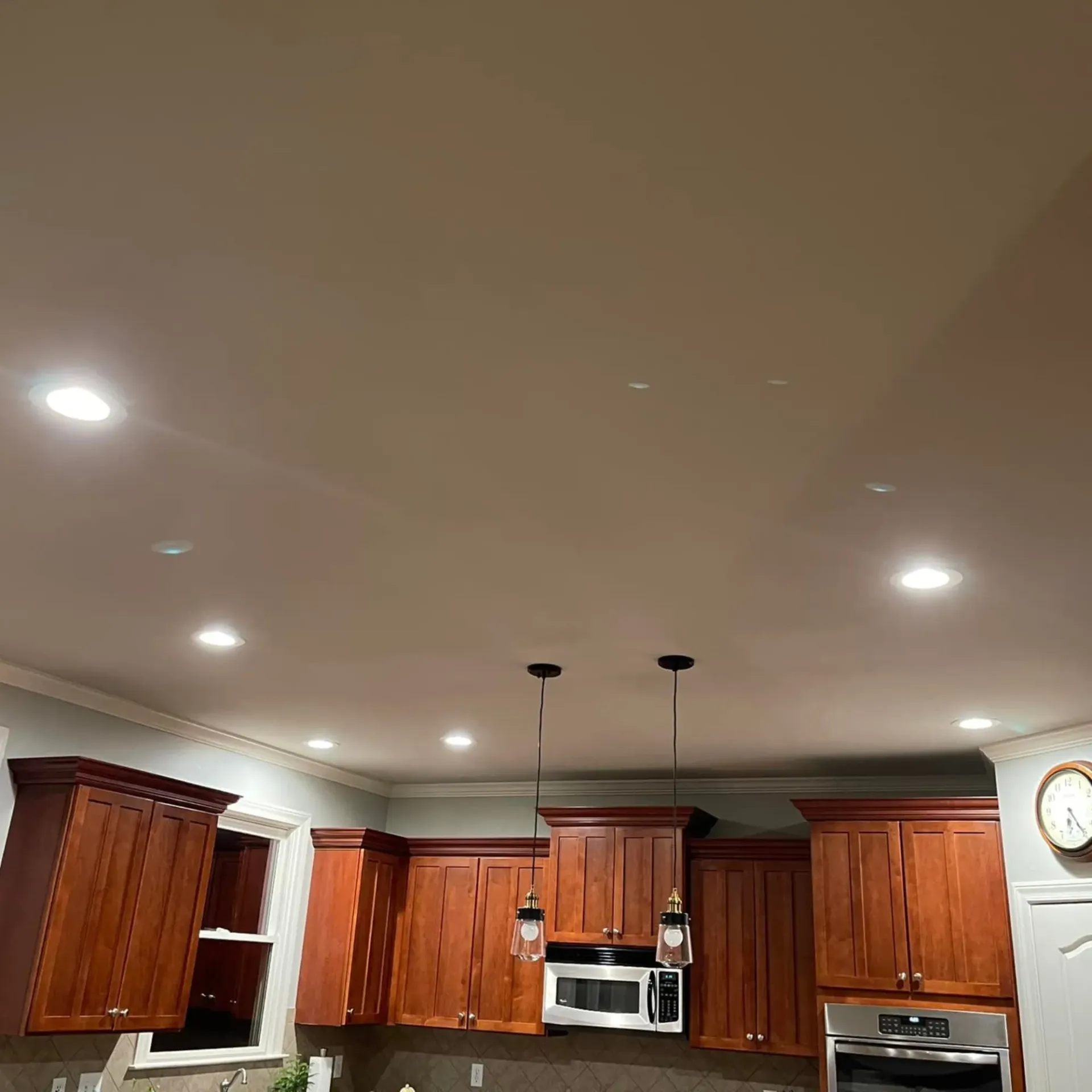 Kitchen ceiling with LED recessed lighting and pendant lights above island