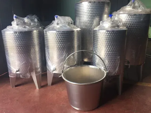 Serbatoi in acciaio inossidabile e un secchio in una stanza, pronti per l'uso.