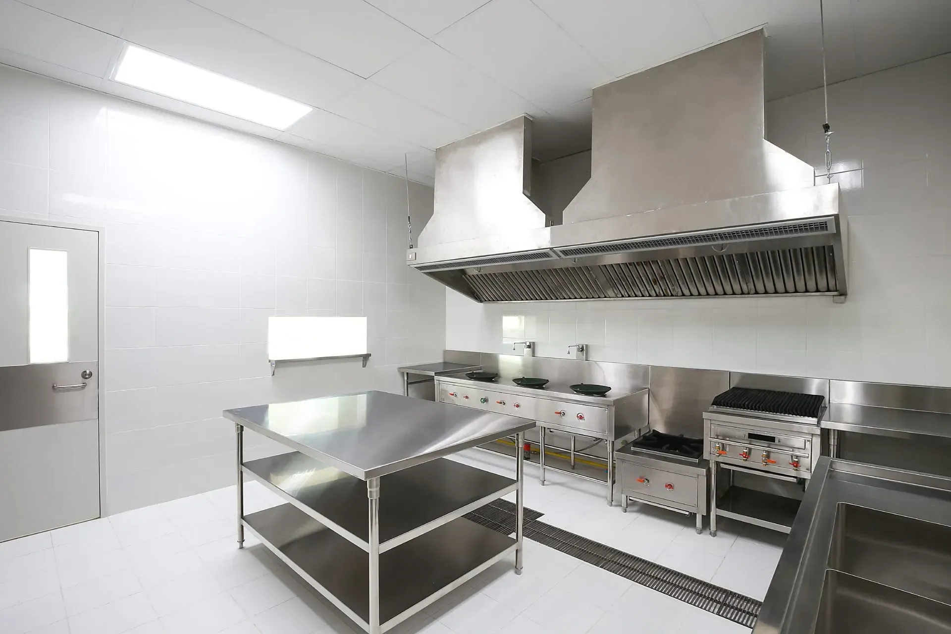 Interno di un ufficio moderno con scale metalliche intersecate, ringhiere in vetro e pavimenti in cemento. 