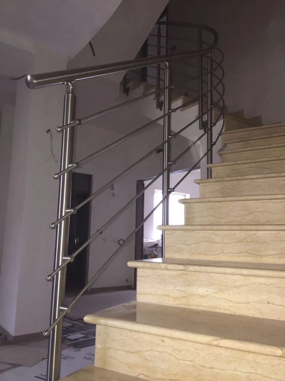 Scala con gradini in marmo e ringhiera in acciaio inox.