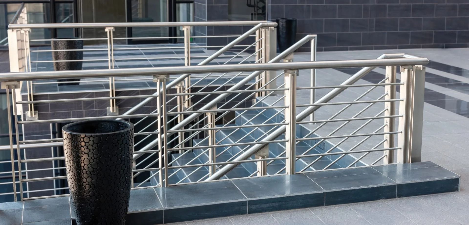 Grandi serbatoi cilindrici di stoccaggio in metallo in un impianto industriale; tubature rosse.