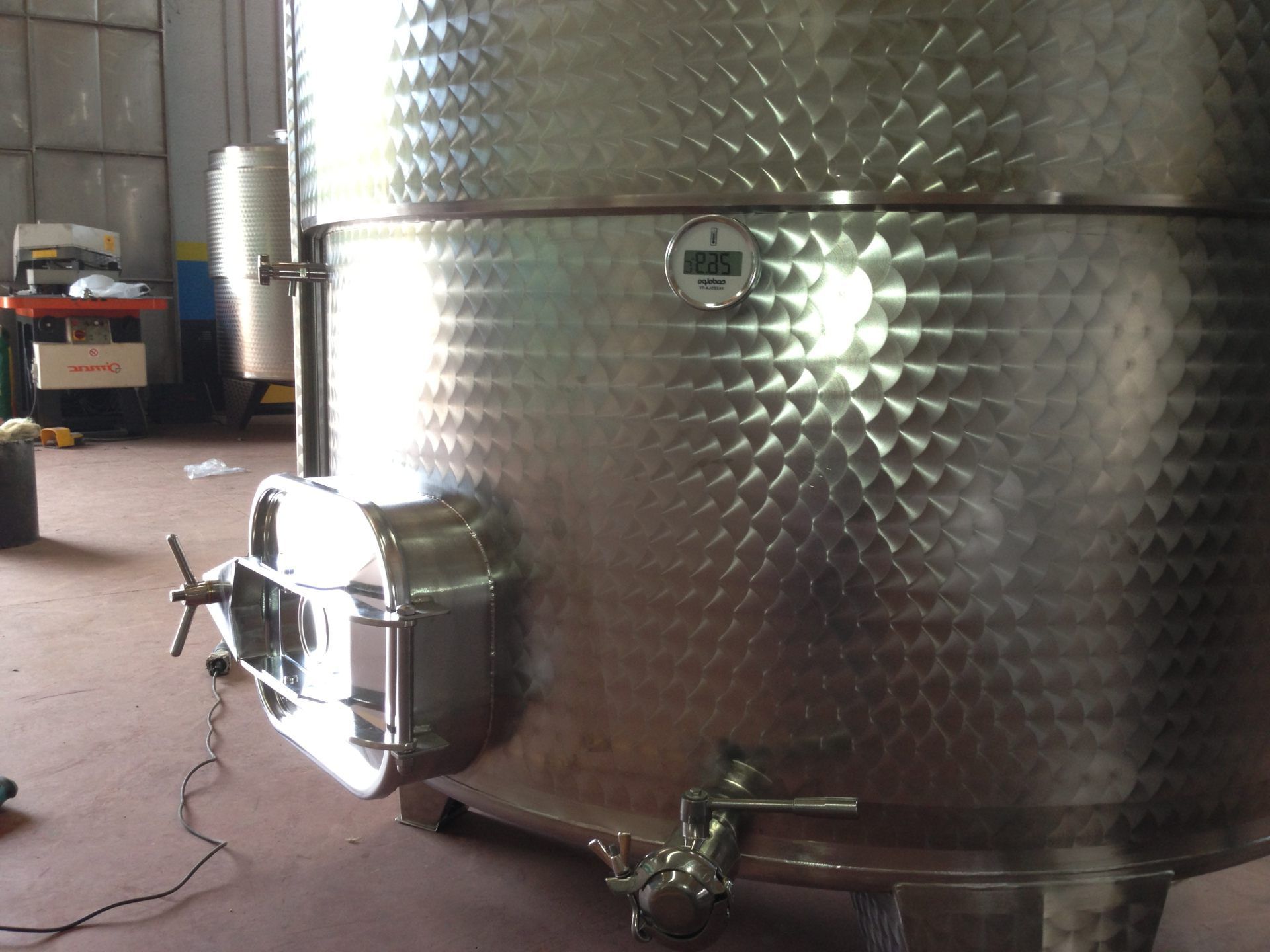 Quattro grandi serbatoi di stoccaggio metallici sferici in un impianto industriale, circondati da tubi e passerelle.