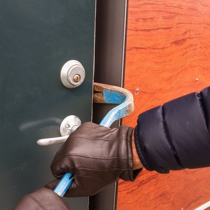 A person is trying to break into a door with a bar