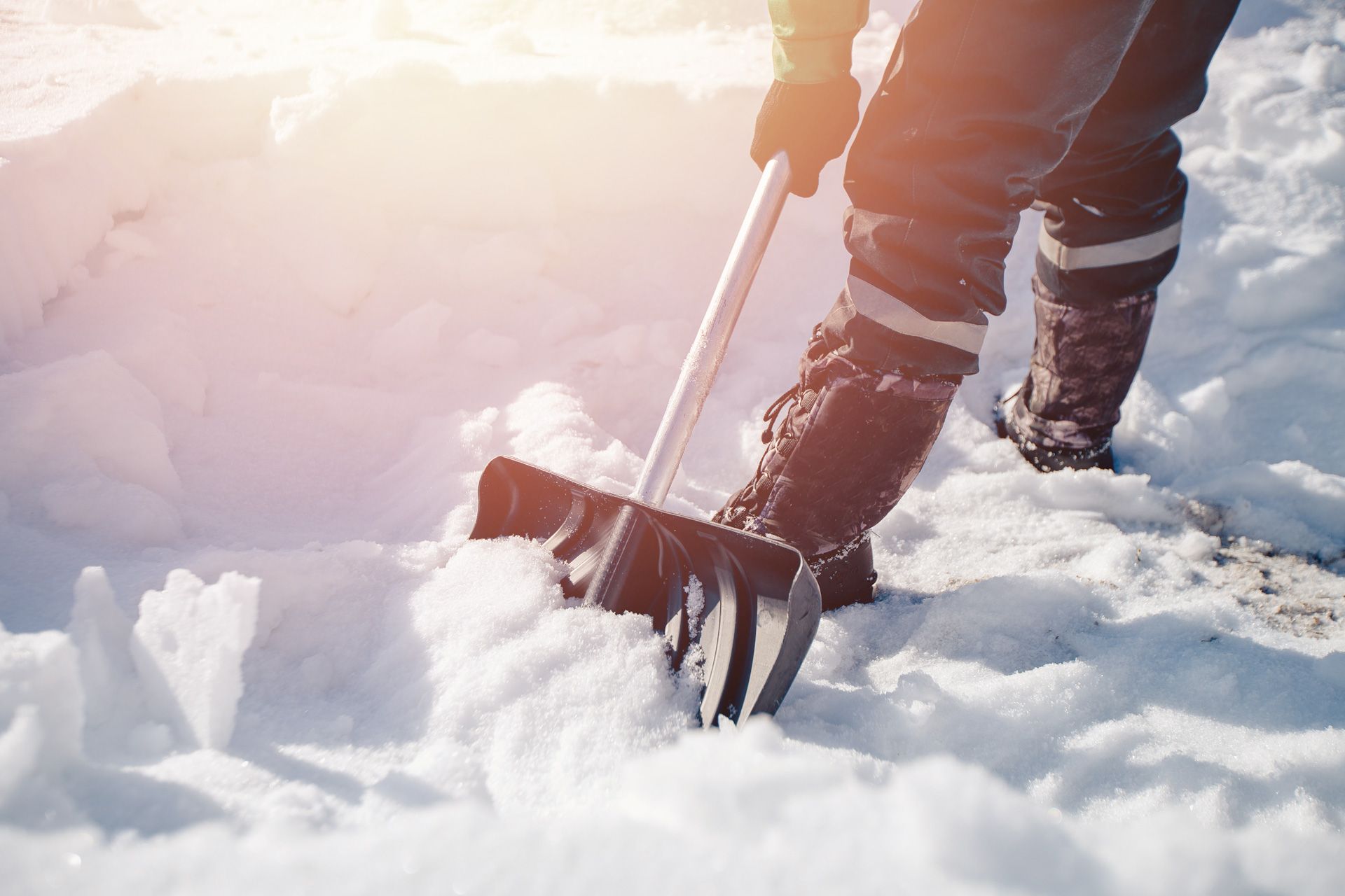 A person is shoveling snow with a large shovel
