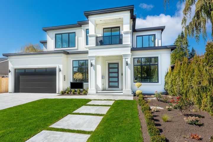 A large white house with a black garage door