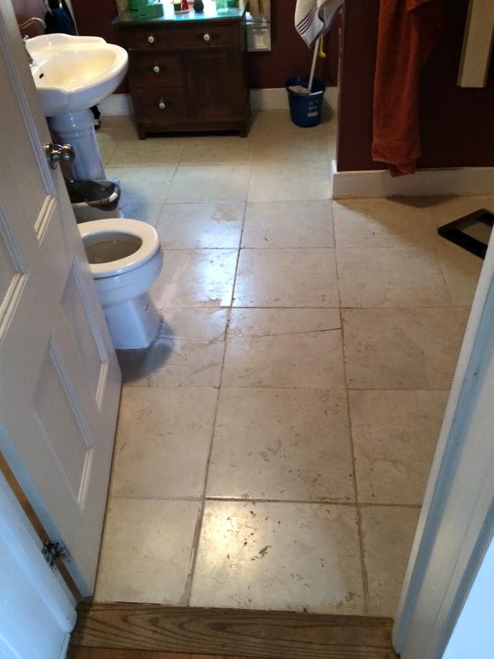 A bathroom with a toilet a sink and a mop