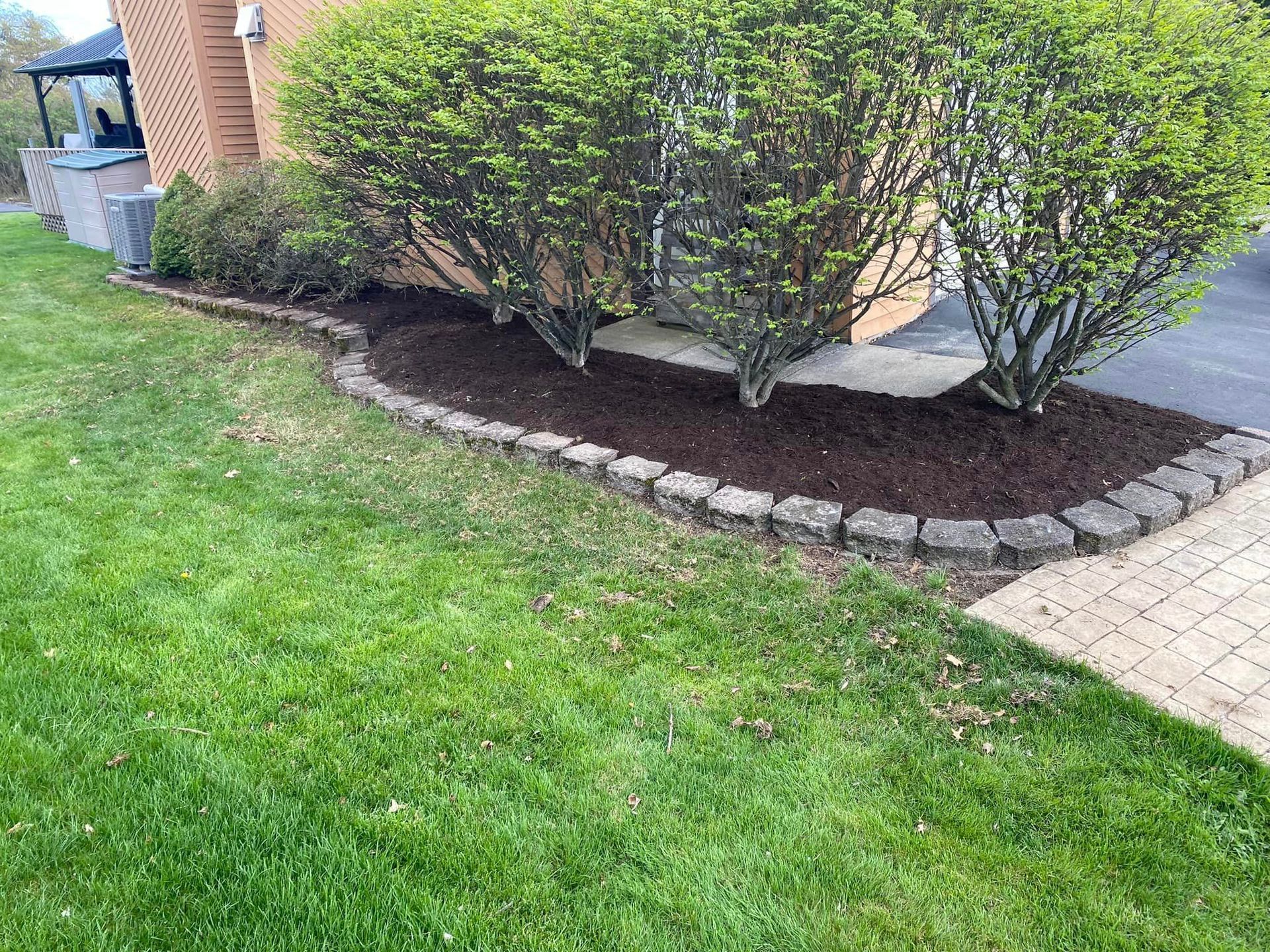 Alush green lawn with a brick walkway leading to a house